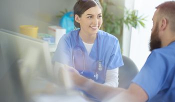 Two nurses talking at a desk