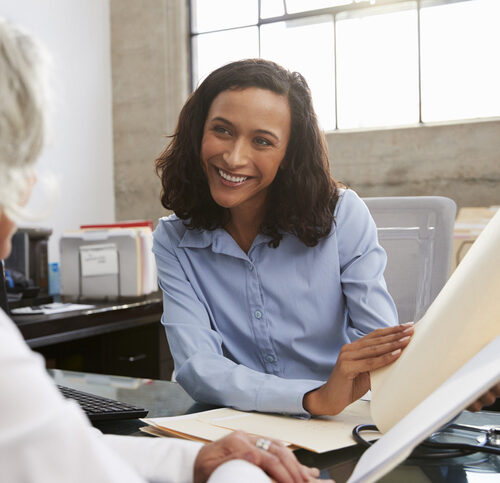 Smiling female analyst in consultation with senior woman