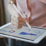 close up on businesswoman manager hand using stylus pen for writing or comment on screen dashboard tablet in meeting situation about company's performance , technology and business strategy concept