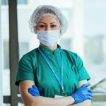 Portrait of surgeon standing with her arms crossed at medical clinic and looking at camera.